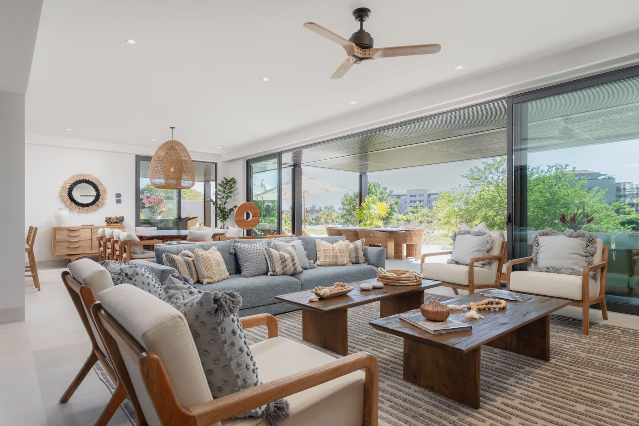 Bright, open living room of a Punta Mita villa with sliding glass doors to the terrace and garden